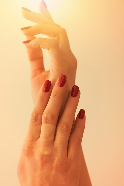 个轻女人的手特写,白色背景下,指甲上长长的红色指甲图片