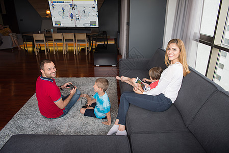 幸福的家庭爸爸妈妈孩子们玩曲棍球电子游戏,爸爸儿子地板上玩电子游戏图片