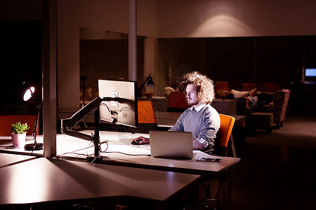 晚上黑暗的办公室里用电脑工作的轻人师稍后的时间工作图片