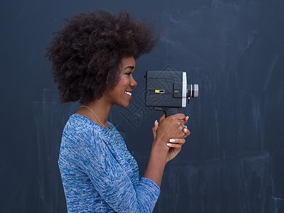 位轻美丽的非裔美国妇女用复古摄像机隔离灰色背景上图片