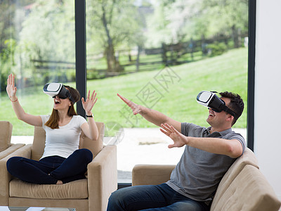 夫妇用虚拟现实耳机客厅家里,人们玩游戏与新的趋势技术图片