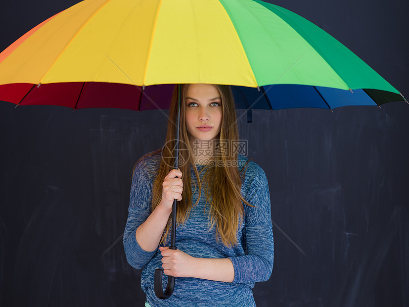 位轻英俊的女人的肖像,她带着把五颜六色的雨伞,孤立灰色的背景上图片