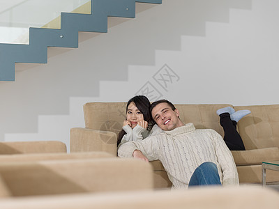 轻的多民族夫妇豪华客厅的沙发上放松高清图片