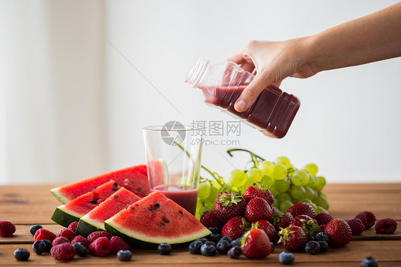 健康的饮食,食物,节食素食的手倒水果浆果汁冰沙瓶子璃图片