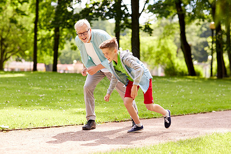 家庭世代人的快乐的祖父孙子夏季公园比赛图片