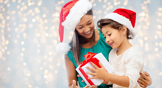 诞节,假日,庆祝,家庭人的快乐的母亲孩子女孩诞老人帮助帽子与礼品盒灯光背景图片