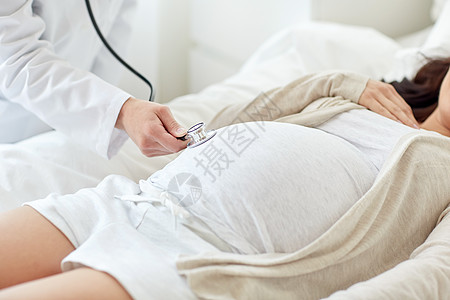 孕妇和医生怀孕,医学,医疗人的密切产科医生与听诊器,听孕妇婴儿心跳医院背景