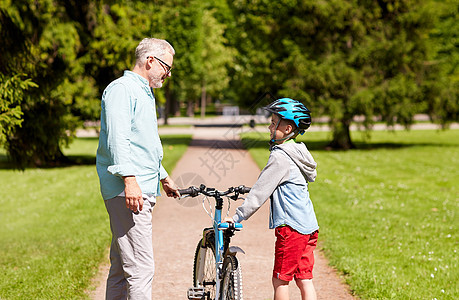 家庭,世代,安全人的快乐的祖父男孩,自行车自行车头盔夏季公园交谈图片