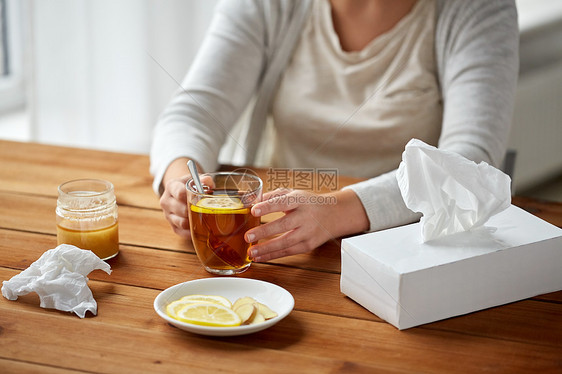 健康传统医学民族科学木桌上用柠檬蜂蜜生姜喝茶的病妇图片