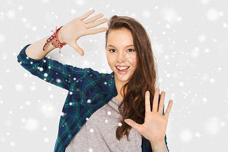 冬天,诞节,人青少的快乐的微笑,漂亮的十几岁的女孩灰色的背景雪上举手图片