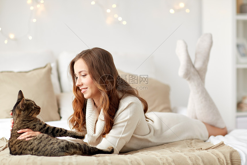 宠物,舒适,诞节,冬天人们的快乐的轻女人猫躺家里的床上图片