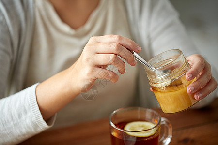 健康,传统医学民族科学的密切妇女添加蜂蜜与柠檬茶图片