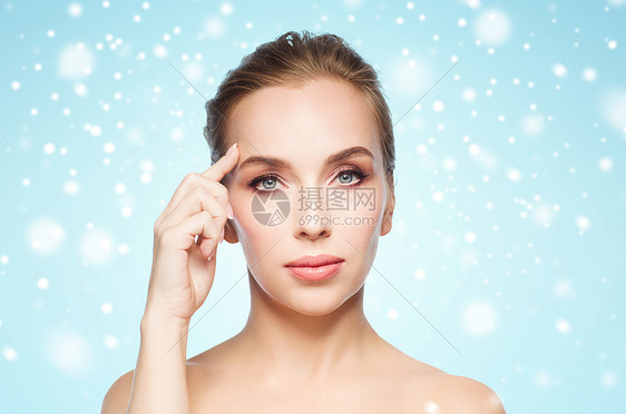 美丽,人冬天的美丽的轻女人展示她的额头蓝色的背景雪图片