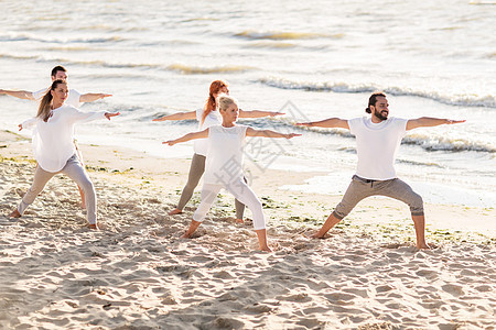 健身,运动健康的生活方式群人海滩上的战士姿势瑜伽图片