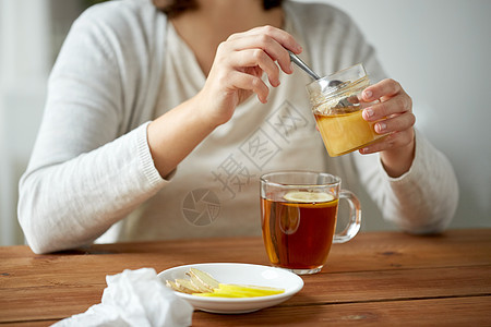健康,传统医学民族科学的密切妇女添加蜂蜜与柠檬茶图片