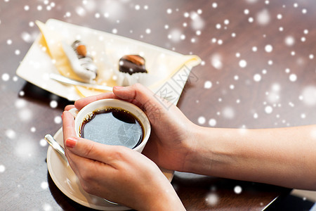 饮料,人寒假的近距离的女人手杯子与黑色咖啡甜点雪地上图片