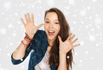 冬天,诞节,人青少的快乐的笑声,漂亮的十几岁的女孩灰色的背景雪上举手图片