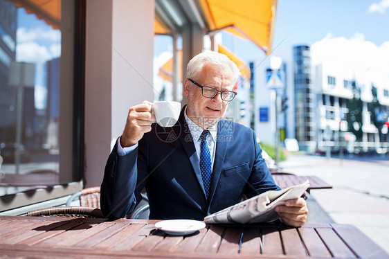 商业,大众媒体,新闻人的高级商人阅读报纸喝咖啡城市街道咖啡馆报纸喝咖啡的高级商人图片