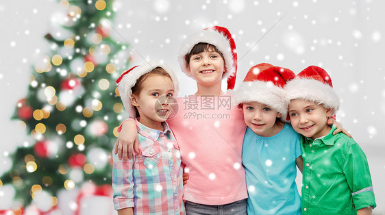 童,寒假,友谊人的群快乐的微笑的孩子戴着诞老人的帽子拥抱诞树雪上图片