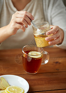 健康食品,饮食民族科学密切妇女添加蜂蜜与柠檬生姜茶杯图片