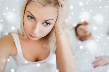 人,健康,睡眠障碍的夫妇床上家,男人打鼾轻的女人遭受失眠的雪图片