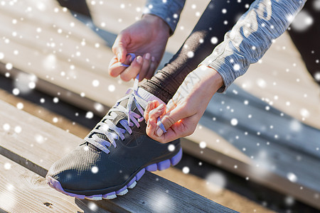 健身,运动,人健康的生活方式的近距离的轻运动妇女绑鞋带户外雪图片