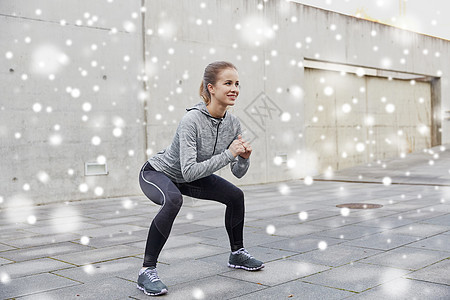 健身,运动,锻炼健康的生活方式快乐的女人户外蹲雪地上图片