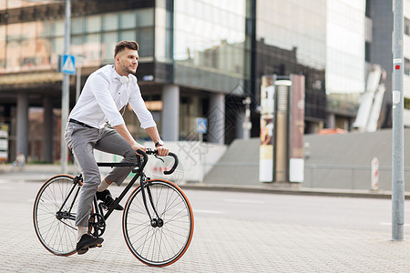 生活方式,交通人们的轻人戴着耳机骑自行车城市街道图片