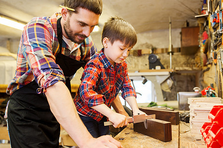 家庭,木工,木工人的父亲小儿子用卡尺测量木板车间图片