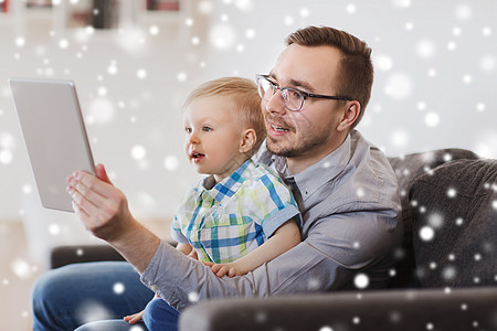 家庭,童,父亲,技术人的快乐的父子与平板电脑电脑家里玩雪图片
