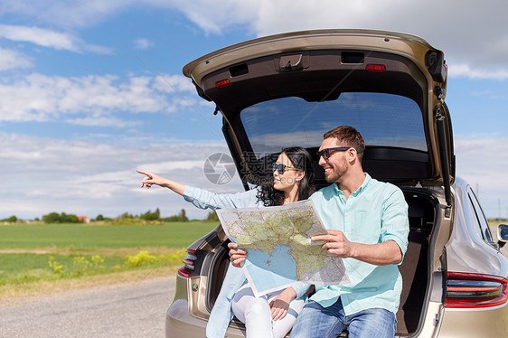 休闲,公路旅行,旅行人们的快乐的男人女人上搜索位置,坐户外的掀背车后备箱上图片