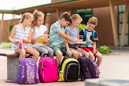 小学教育,友谊,童,沟通人的群快乐的小学生,背包笔记本坐户外长凳上图片