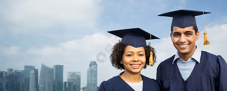 教育,毕业人的快乐的国际学生砂浆板学士礼服新加坡城市摩天大楼的背景图片