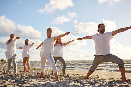 健身,运动,瑜伽健康的生活方式群人海滩上战士的姿势图片