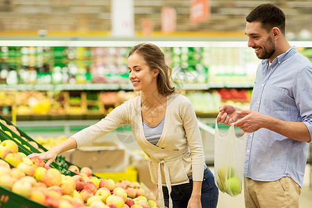 购物食品销售消费主义人们的观念幸福的夫妇杂货店超市买苹果图片