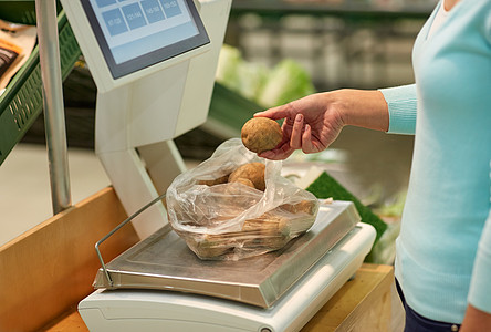 购物销售消费主义人们的观念杂货店里秤土豆的女人图片