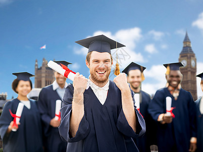 教育手势人的群快乐的国际学生穿着灰浆板学士礼服,伦敦城市背景下庆祝成功毕业图片