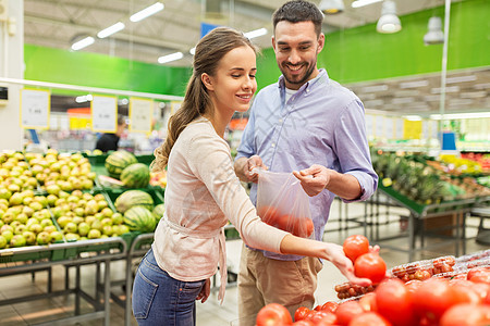 购物,食品,销售,消费主义人们的幸福的夫妇购买西红柿杂货店超市图片