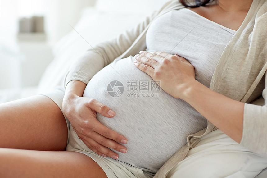 ‘~怀孕,休息,人期望密切孕妇躺床上,触摸她的肚子家里  ~’ 的图片
