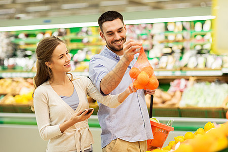 购物,食品,销售,消费主义人的幸福的夫妇与智能手机购买橘子杂货店超市图片