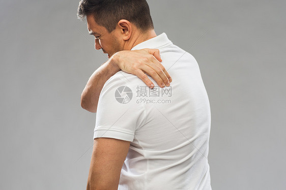人,医疗保健问题密切的人遭受疼痛上背部灰色背景图片
