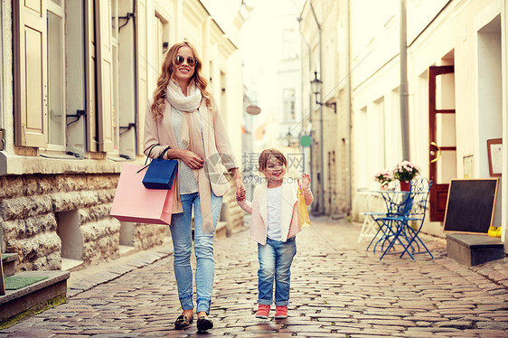 销售,消费主义人们的快乐的母亲孩子与购物袋走城市街道图片