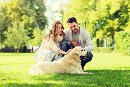 家庭,宠物,动物人的幸福的夫妇与拉布拉多猎犬城市公园散步图片