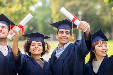 教育毕业人的群快乐的国际学生穿着灰浆板学士服,毕业证书庆祝成功礼服高清图片素材
