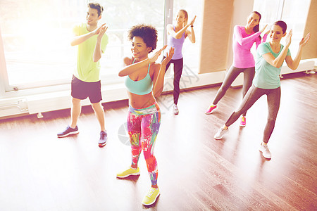 健身,运动,舞蹈生活方式的群微笑的人与教练健身房工作室跳舞图片