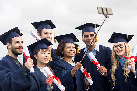 教育,毕业,技术人的群快乐的国际学生砂浆板学士学位礼服与文凭采取自拍智能手机户外图片