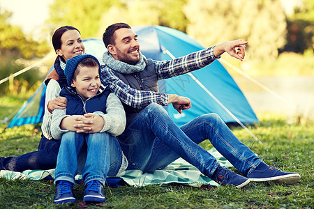 露营,旅游,徒步旅行人们的快乐的家庭帐篷营地场景指指点点图片