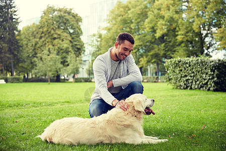 家庭,宠物,动物人的快乐的人与拉布拉多猎犬城市公园散步图片