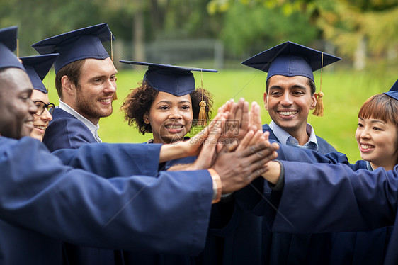 教育毕业人的群快乐的国际学生穿着灰浆板学士学位服,身高五图片