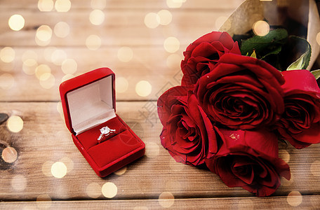 爱,建议,情人节假日礼品盒与钻石订婚戒指红玫瑰木材上的灯光背景复古效果图片